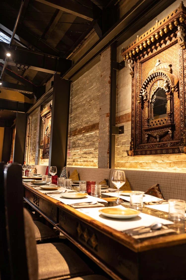 Restaurant interior with warm architectural lighting along a brick wall